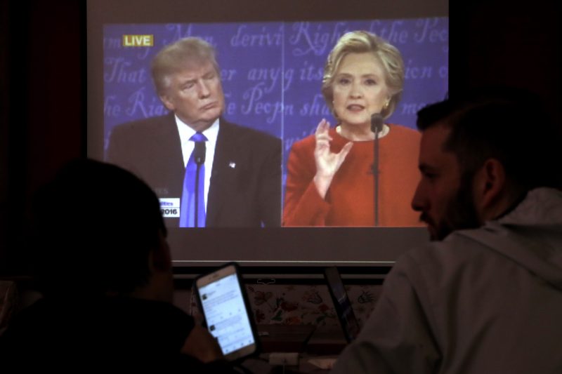 People chat as they watch a live broadcasting of the U.S. Presidential debate