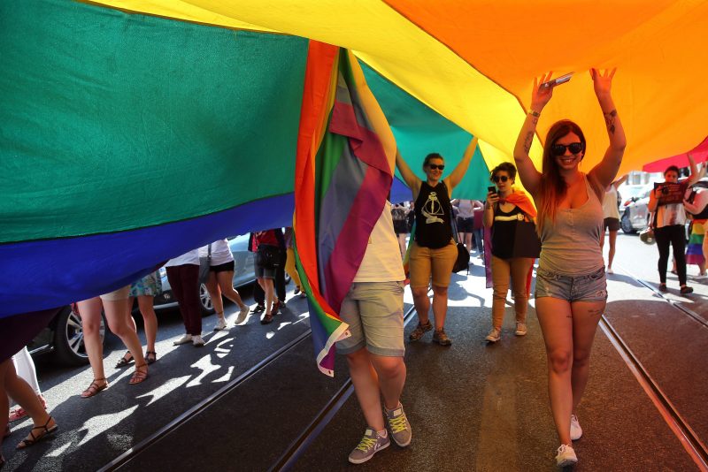 2015-06-20 18:21:44 epa04811406 Several women walk under the rainbow flag during the 16th Lisbon gay pride parade against the discrimination of lesbian, gay, bisexual, and transgender (LGBT) people, in Lisbon, Portugal, 20 June 2015. EPA/TIAGO PETINGA