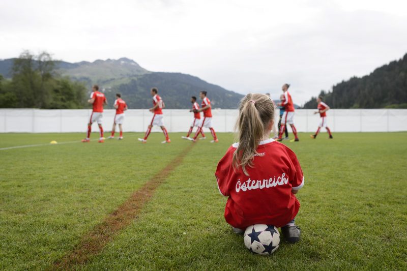 2016-05-26 17:03:01 epa05330837 A girl with a T-Shirt reading 'Austria' watches Austria's players warm up, during a test match between Austria's National Soccer Team and the local team US Schluein Ilanz in Schluein, canton of Grisons, Switzerland, 26 May 2016. The Austrian National Soccer Team prepares in the region for the UEFA Euro 2016. EPA/GIAN EHRENZELLER
