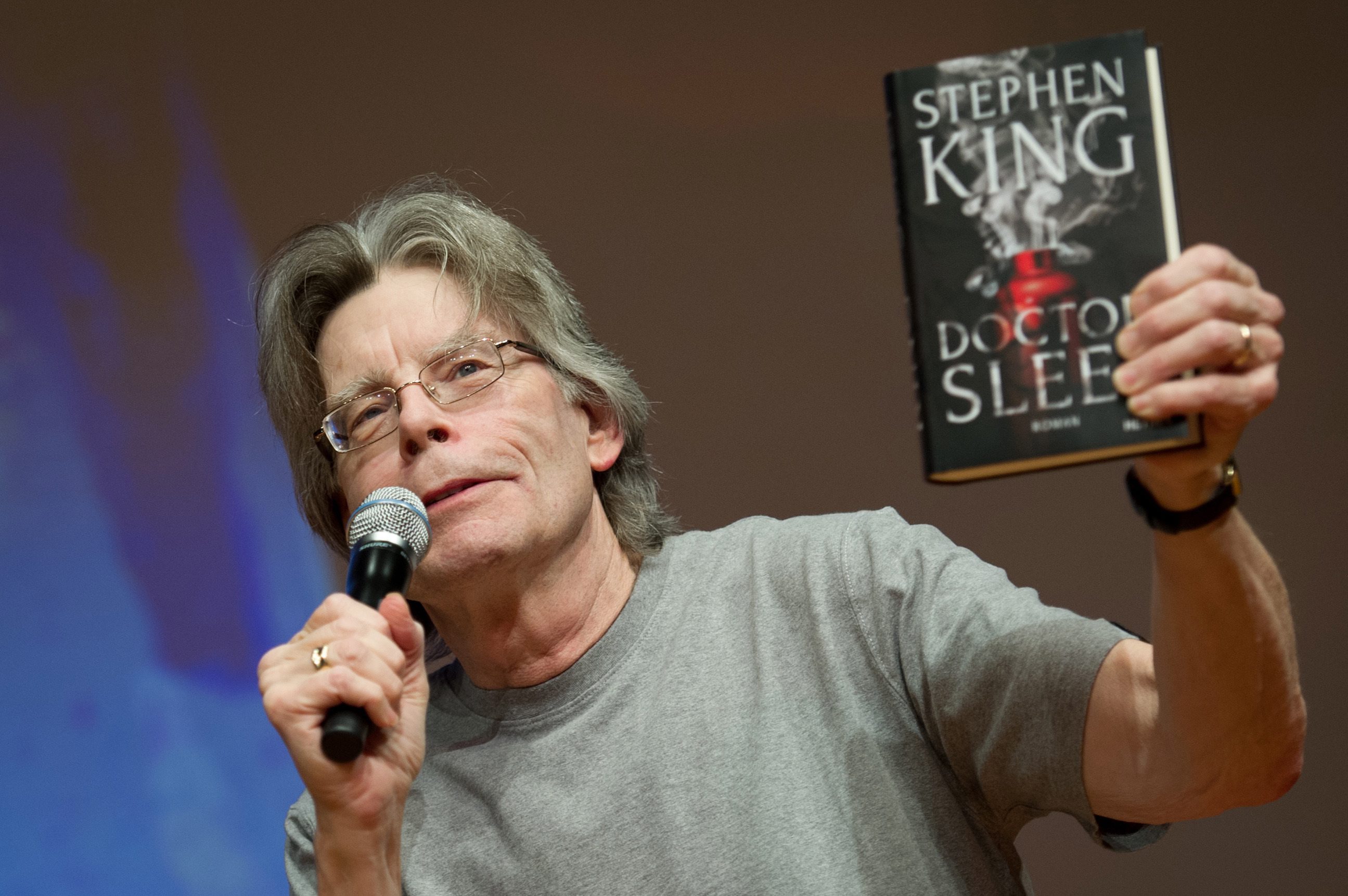 2013-11-20 00:00:00 epa03958623 US witer Stephen King holds a copy of his new book 'Doctor Sleep' during a reading at the Congress Centrum in Hamburg, Germany, 20 November 2013. EPA/MAJA HITIJ