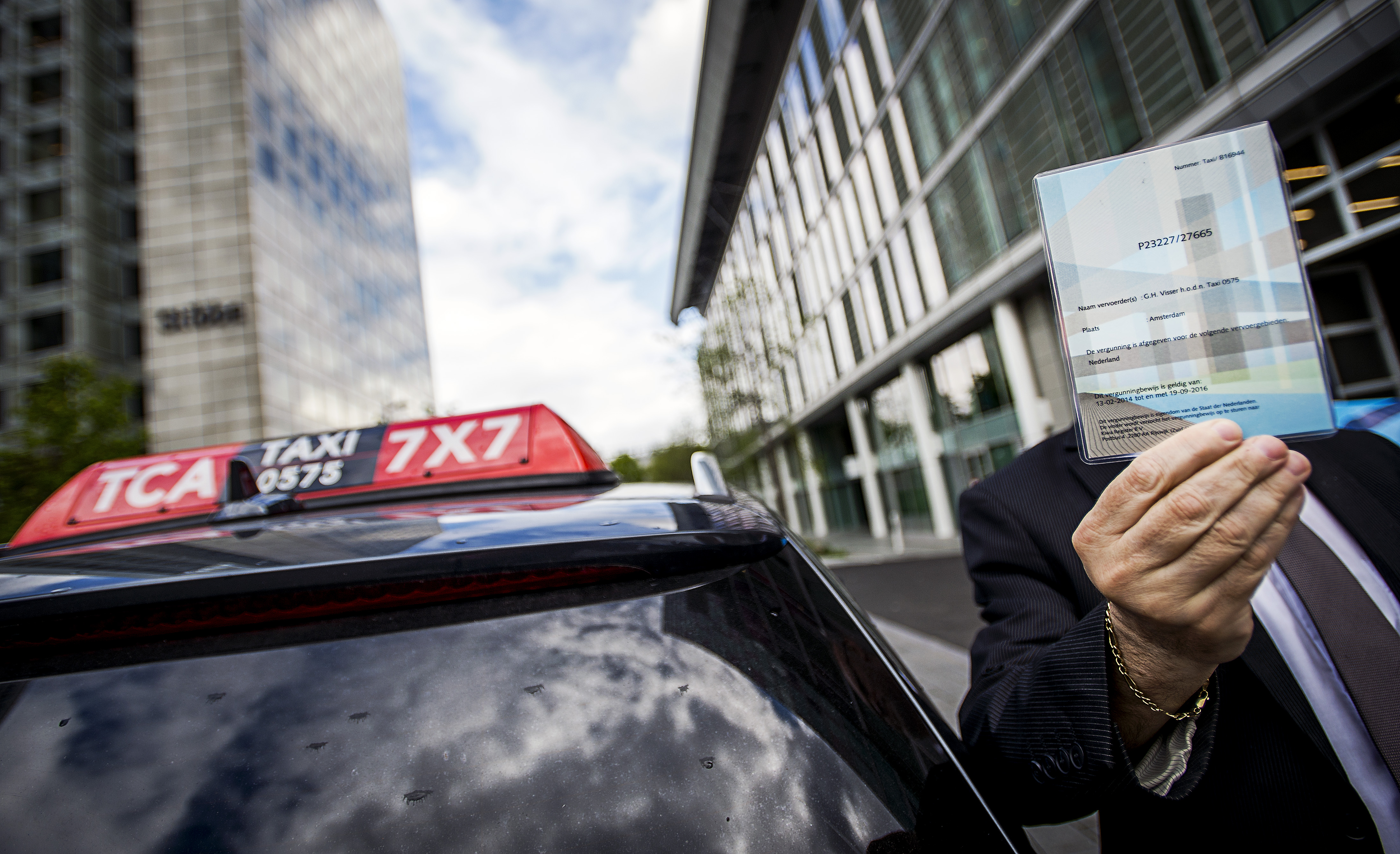 2015-05-06 11:59:33 AMSTERDAM - Een chauffeur van Taxi Centrale Amsterdam (TCA) toont zijn vergunning. ANP REMKO DE WAAL