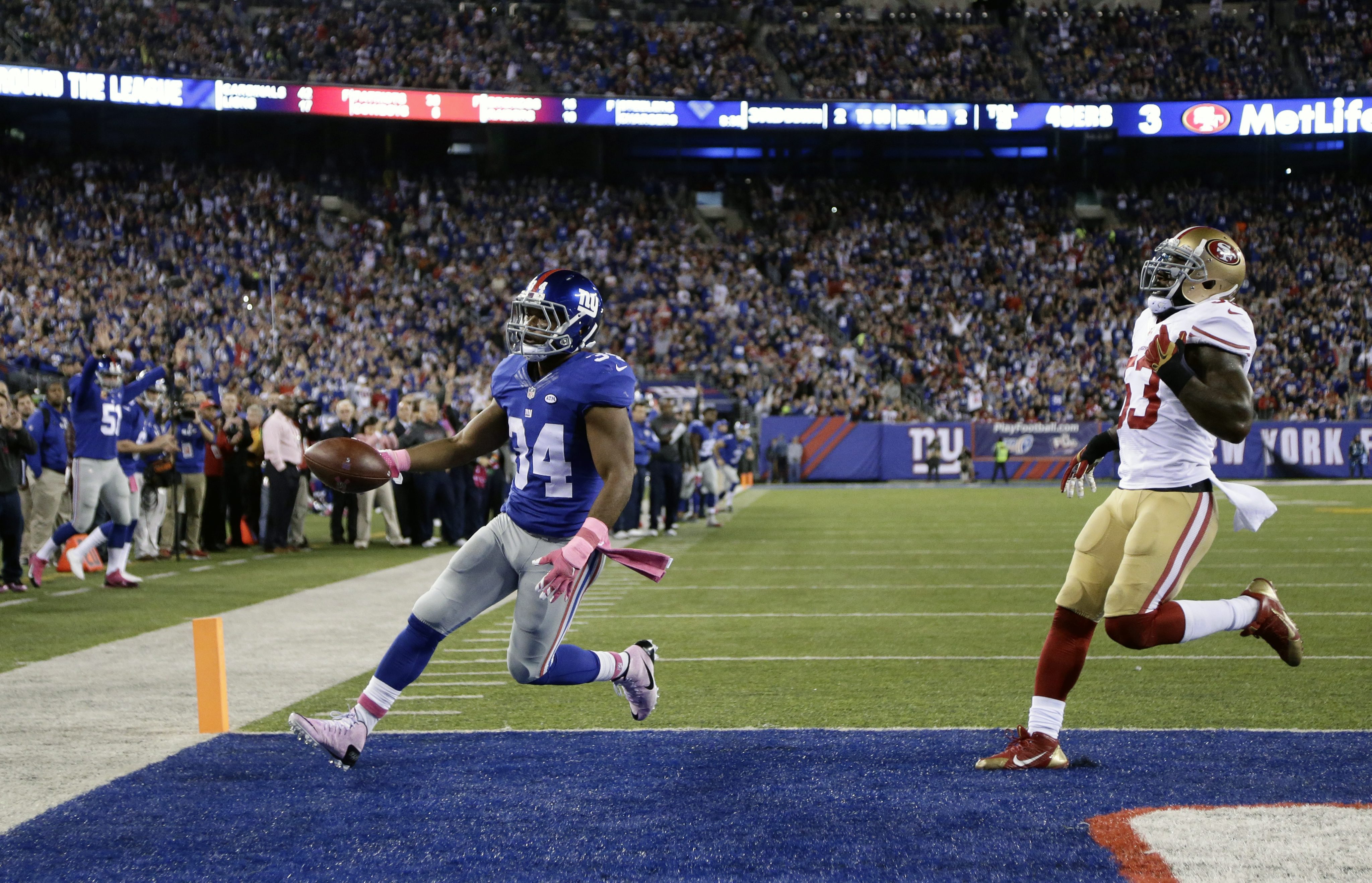 2015-10-11 21:05:25 epa04974408 New York Giants running back Shane Vereen (L) celebrates as he runs into the end zone for a touch down past San Francisco 49ers inside linebacker NaVorro Bowman in the second quarter of their NFL game at MetLife Stadium in East Rutherford, New Jersey, USA, 11 October 2015. EPA/JASON SZENES