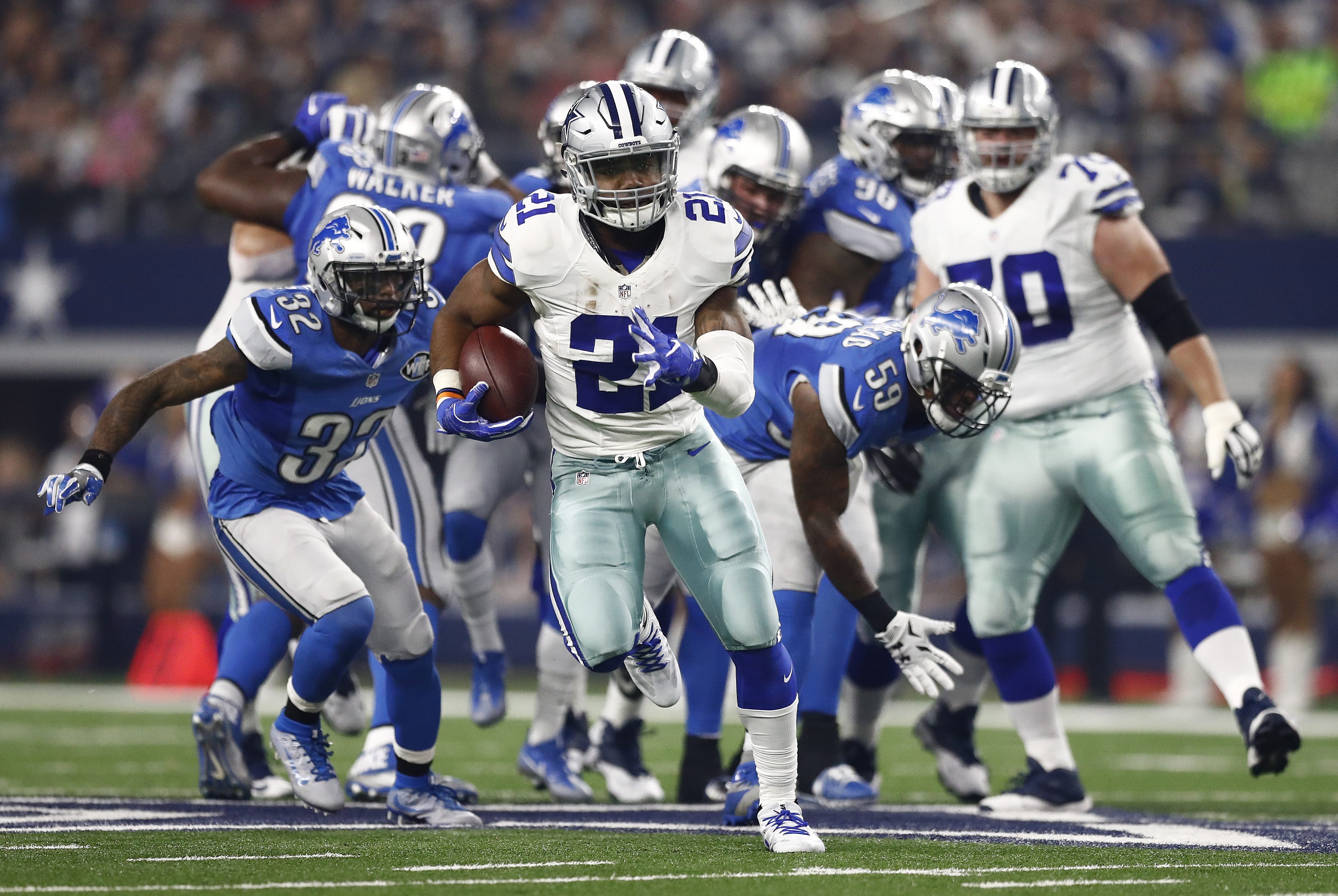 2016-12-26 07:49:01 epa05689029 Dallas Cowboys player Ezekiel Elliott (C) runs the ball for a touchdown in the first half of the NFL game between the Detroit Lions and the Dallas Cowboys in Arlington, Texas, USA, 26 December 2016. EPA/LARRY W. SMITH