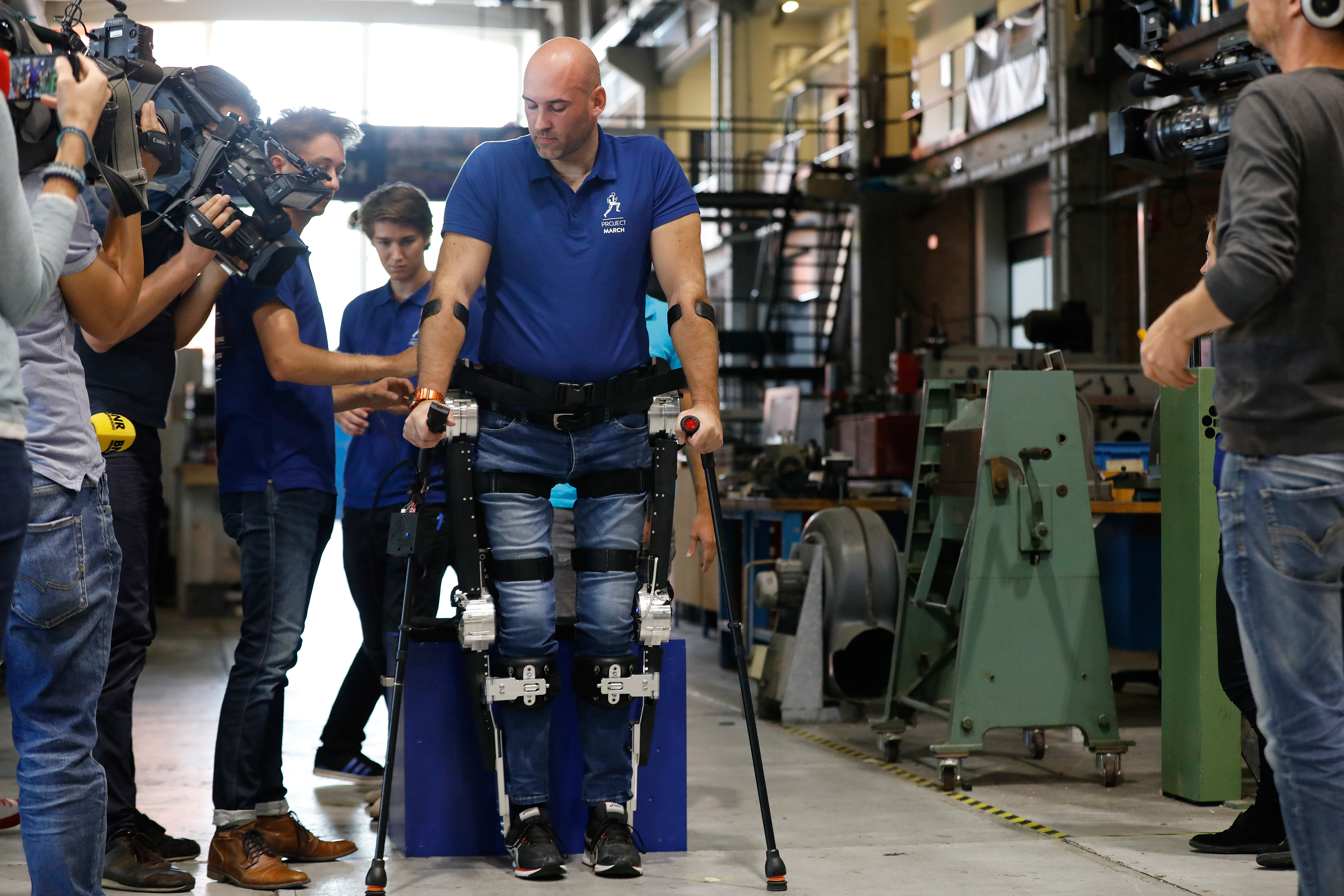 2017-08-31 11:17:23 DELFT - Dwarslaesiepatient Ruben de Sain zet de eerste stappen in het exoskelet van de TU Delft. Het ondersteunend robotisch pak, de MARCH II, is ontwikkeld door een team Delftse studenten. ANP BAS CZERWINSKI