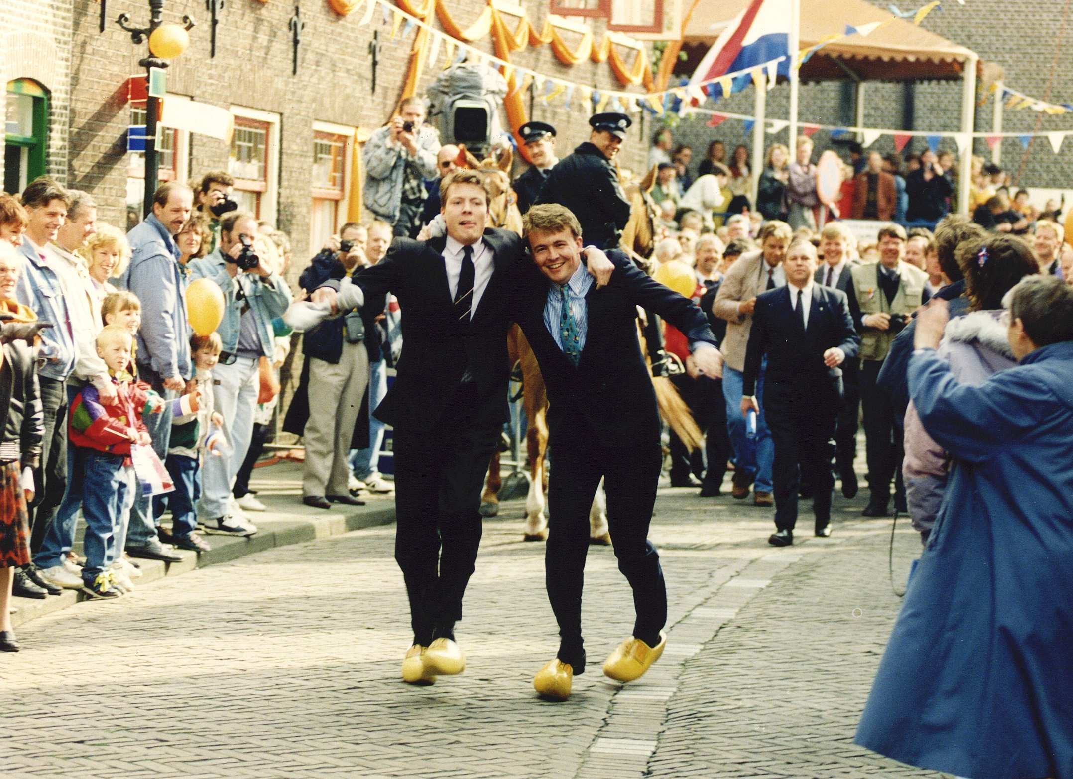 1992-04-30 12:00:00 Twee opvallende Hollandse jongens vieren Koninginnedag met een klompendans in Overschie: de prinsen Constantijn (l) en Friso, nagestaand door de bevolking van de Rotterdamse wijk Overschie.