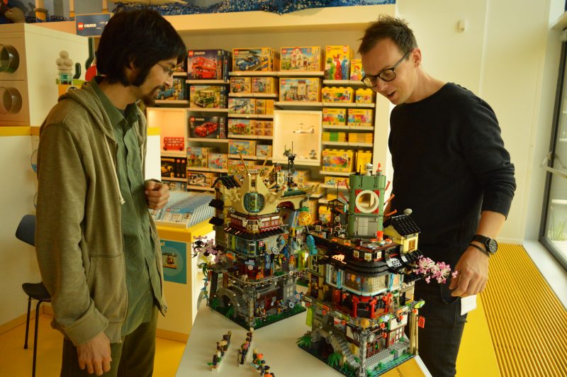 Nicolaas Vás (links) en Simon Lucas bij twee versies van de Ninjago City-set, waarvan de rechter uiteindelijk in de winkels ligt. Foto: Koen Verhelst
