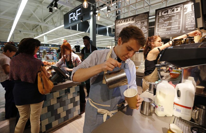 A barista makes a latte at the Harris and Hoole coffee shop inside a Tesco Extra supermarket in Watford, north of London August 8, 2013. Tesco, the world's number three retailer, is hoping the allure of casual dining, coffees and even yoga will help tempt Britons back to its ailing retail park stores as part of a 1 billion pound ($1.55 billion) push to revitalise business.