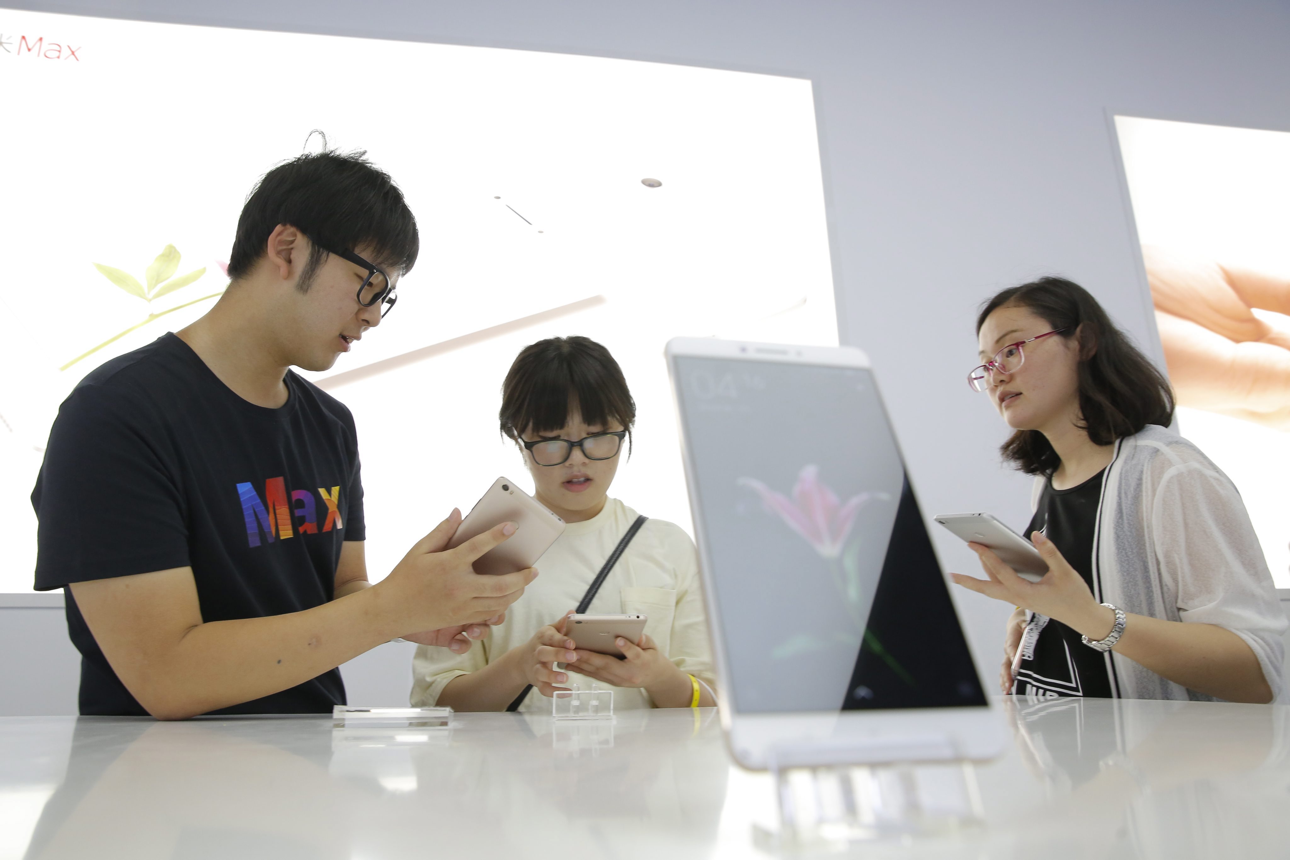 2016-05-10 14:49:13 epa05297510 Visitors experience the new smartphone 'Xiaomi Max' on show after the Xiaomi product launch ceremony in Beijing, China, 10 May 2016. Xiaomi released a new mobile phone 'Xiaomi Max' and operating system MIUI 8 on 10 May 2016. EPA/WU HONG