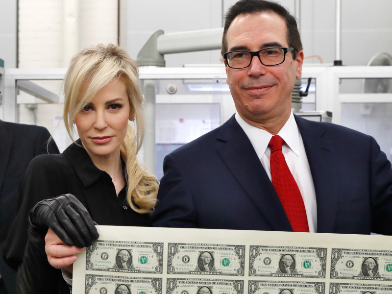 Treasury Secretary Steven Mnuchin, right, and his wife Louise Linton, hold up a sheet of new $1 bills, the first currency notes bearing his and U.S. Treasurer Jovita Carranza's signatures, Wednesday, Nov. 15, 2017,