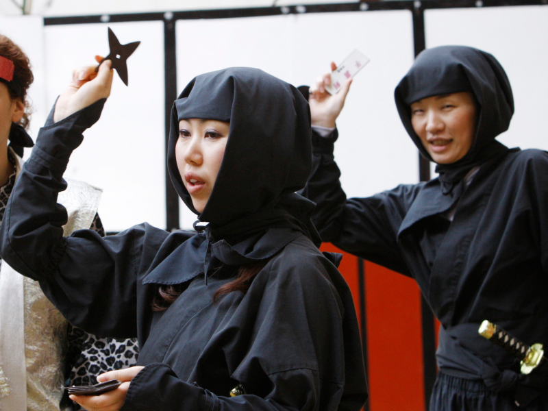 Women dressed as ninjas throw 