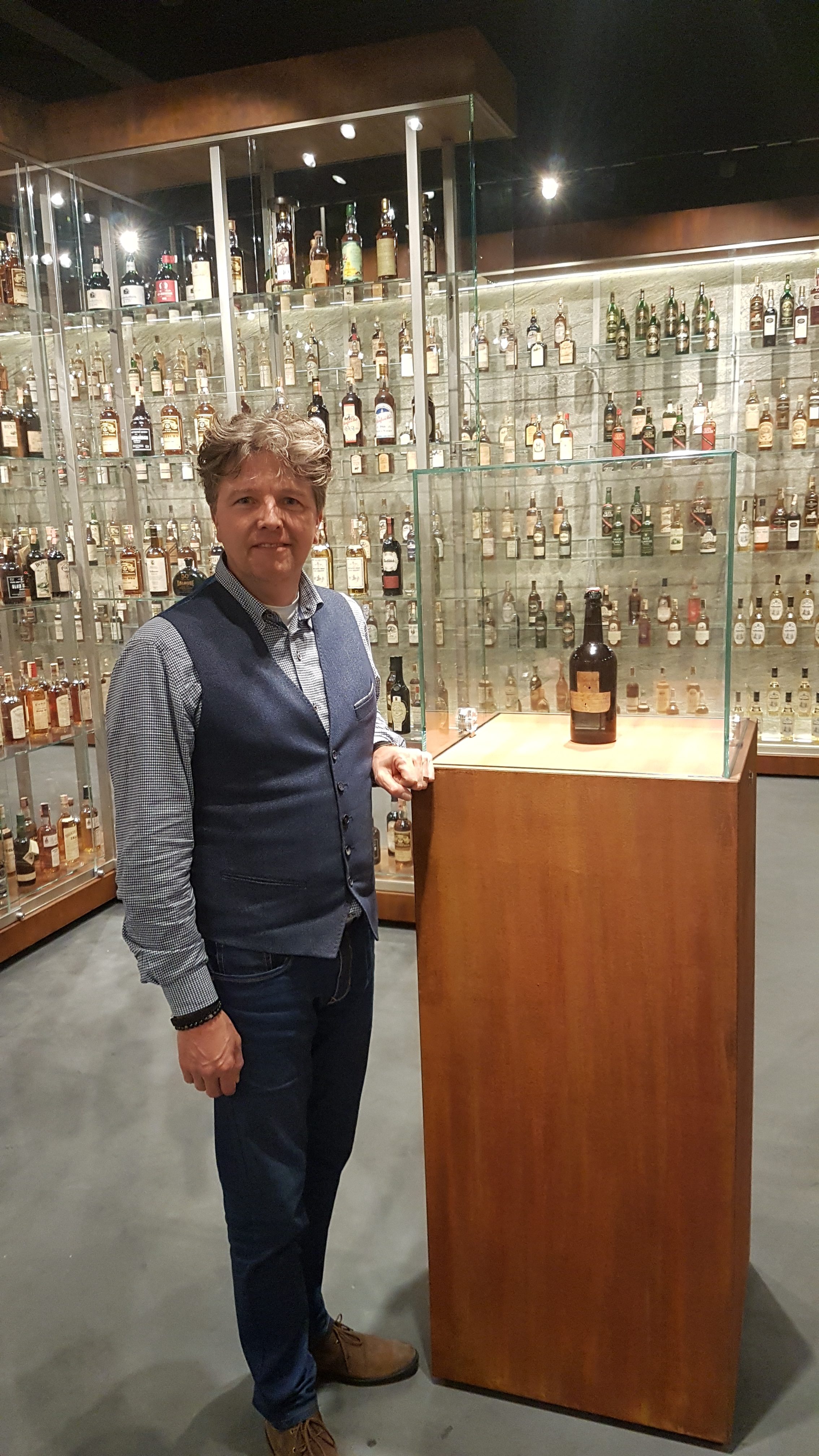 Paul-van-der-Hulst-commercieel-directeur-bij-SWI-toont-oudste-fles-in-Zagatti-Museum-Sassenheim Whisky