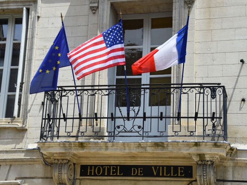 The U.S. flag (C) flies on the balcony of city hall of Villeneuve-les-Avignon, southern France on June 15, 2019, as the former US president Barack Obama and his family visit the city for a week's vacation