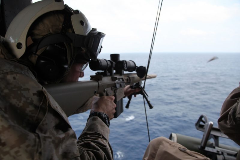Sgt. Hunter G. Bernius, a scout sniper with Weapons Company, Battalion Landing Team 3/1, 11th Marine Expeditionary Unit and Lufkin, Texas native, shoots at a target placed in the water from a UH-1Y Huey during an aerial sniper exercise.