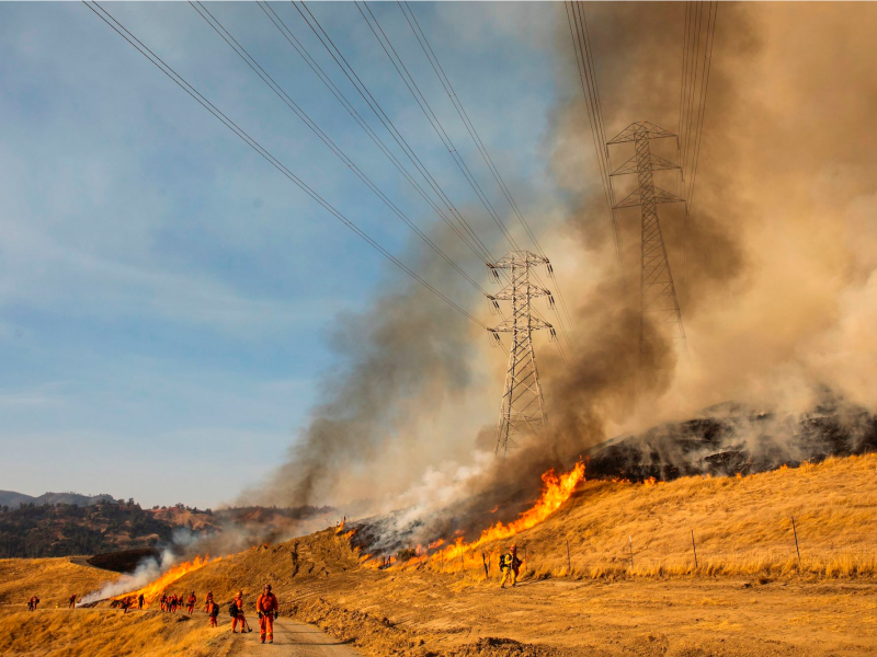 A back fire set by fire fighters burns a hillside near PG&E power lines during firefighting operations to battle the Kincade Fire in Healdsburg, California on October 26, 2019. - US officials on October 26 ordered about 50,000 people to evacuate parts of the San Francisco Bay area in California as hot dry winds are forecast to fan raging wildfires.