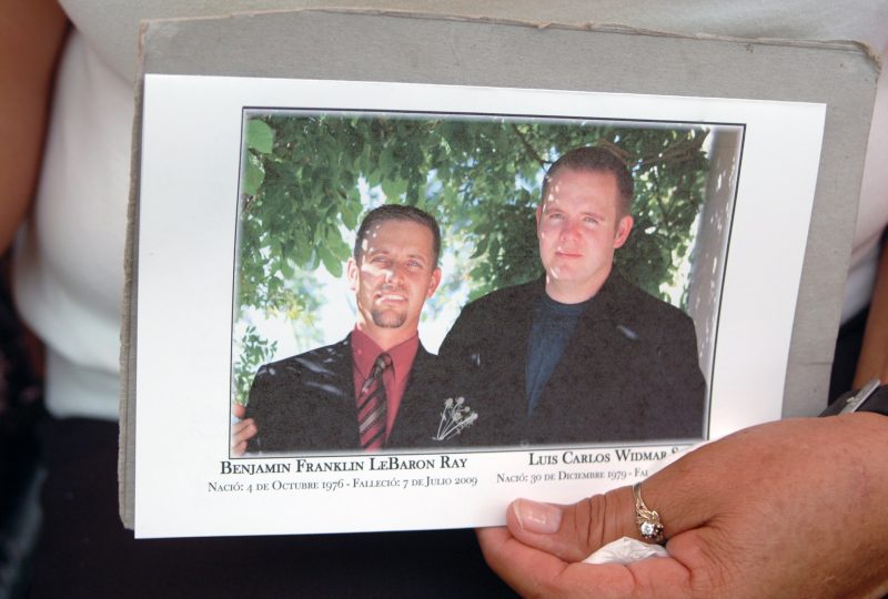 A woman holds a picture of Mormon anti-crime activist Benjamin LeBaron, left, and his neighbor Luis Widmar, who were killed in 2009.