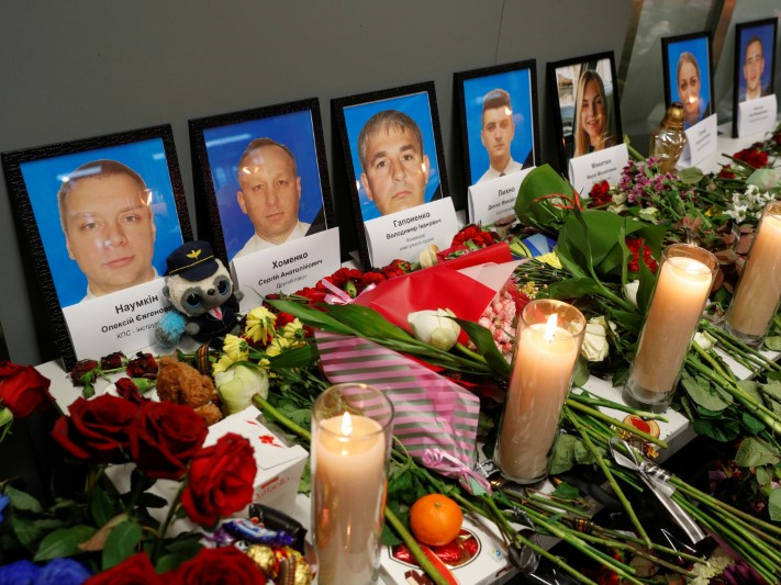 FILE PHOTO: Flowers and candles are placed in front of the portraits of the flight crew members of the Ukraine International Airlines plane that was shot down by Iran, at a memorial at the Boryspil International airport outside Kiev, Ukraine January 11, 2020. REUTERS/Valentyn Ogirenko
