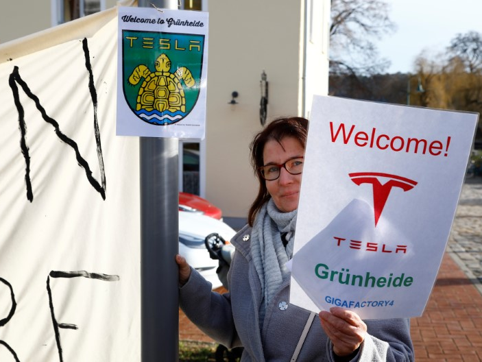 FILE PHOTO: A demonstrators holds pro-Tesla poster during an action to support plans by U.S. electric vehicle pioneer Tesla to build its first European factory and design center in Gruenheide near Berlin, Germany January 18, 2020. REUTERS/Pawel Kopczynski