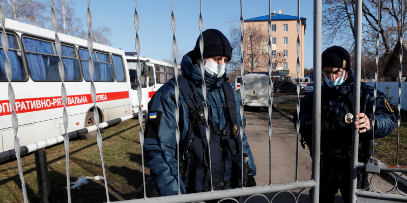 Members of Ukraine's National Guard close the gate of a sanatorium where the evacuees from coronavirus-hit China's Hubei province are quarantined, in the village of Novi Sanzhary in Poltava region, Ukraine February 21, 2020.