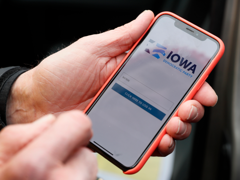 Precinct captain Carl Voss, of Des Moines, Iowa, holds his iPhone that shows the Iowa Democratic Party's caucus reporting app Tuesday, Feb. 4, 2020, in Des Moines, Iowa. (AP Photo/Charlie Neibergall)