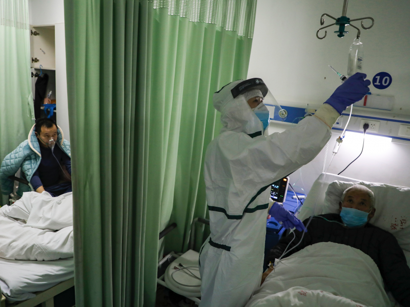 In this Thursday, Feb. 6, 2020, photo, a nurse checks on a patient in the isolation ward for 2019-nCoV patients at a hospital in Wuhan in central China's Hubei province. The number of confirmed cases of the new virus has risen again in China on Saturday, Feb. 8, 2020, as the ruling Communist Party faced anger and recriminations from the public over the death of a doctor who was threatened by police after trying to sound the alarm about the disease over a month ago. (Chinatopix via AP)