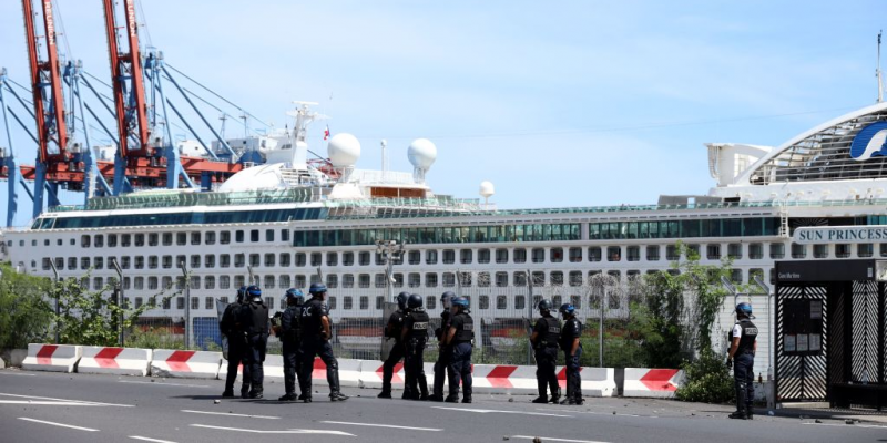 French police officers face demonstrators in Le Port on March 1, 2020, as people protest against the arrival of the passengers of the Sun Princess cruise ship on the Indian Ocean island of La Reunion without having their temperature checked. (Photo by Richard BOUHET /