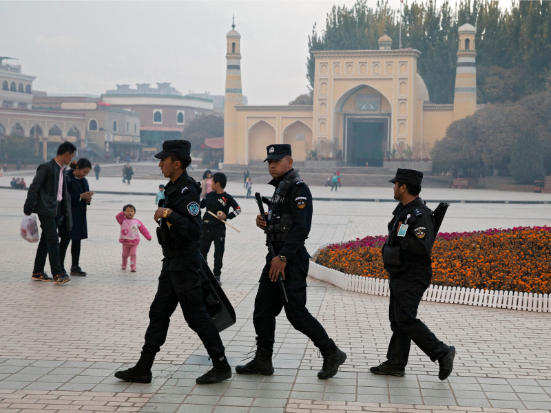 FILE - In this Nov. 4, 2017, file photo, Uighur security personnel patrol near the Id Kah Mosque in Kashgar in western China's Xinjiang region. A database obtained by The Associated Press offers the fullest and most personal view yet into how Chinese officials decided who to put into and let out of detention camps, as part of a massive crackdown that has locked away more than a million ethnic minorities, most of them Muslim. (AP Photo/Ng Han Guan, File)