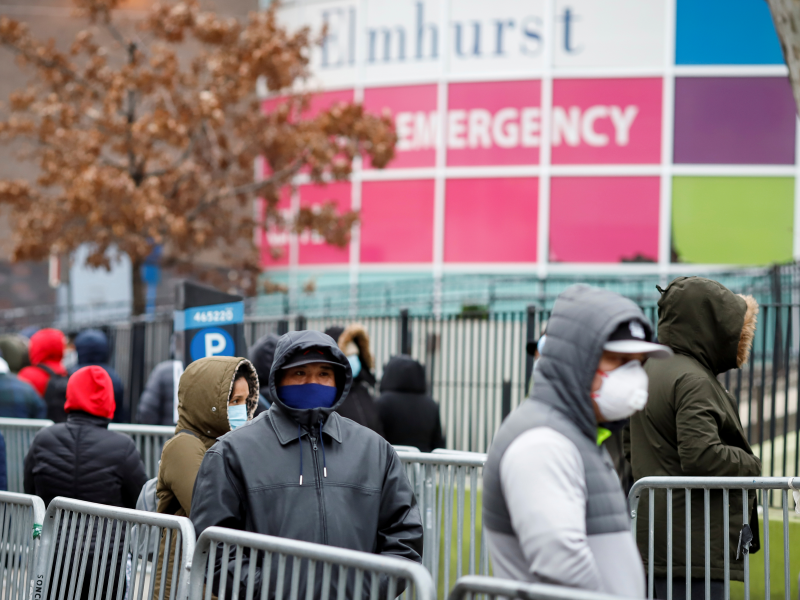 People wait in line tåo be tested for coronavirus disease (COVID-19) while wearing protective gear, outside Elmhurst Hospital Center in the Queens borough of New York City, U.S., March 25, 2020