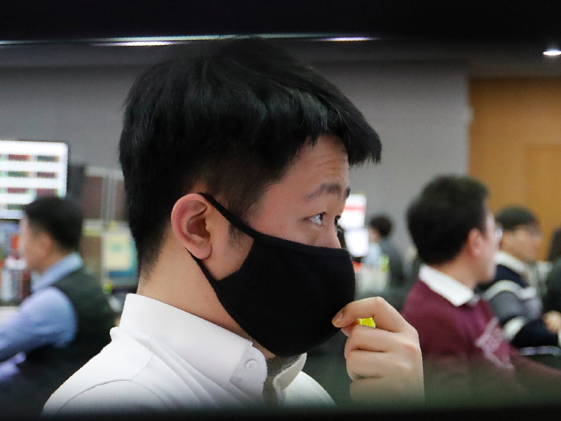 A currency trader wearing a face mask watches monitors at the foreign exchange dealing room of the KEB Hana Bank headquarters in Seoul, South Korea, Thursday, March 5, 2020. Asian shares rose Thursday, taking their cue from a surge on Wall Street as governments and central banks took more aggressive measures to fight the virus outbreak and its effects on the economy.(AP Photo/Ahn Young-joon)