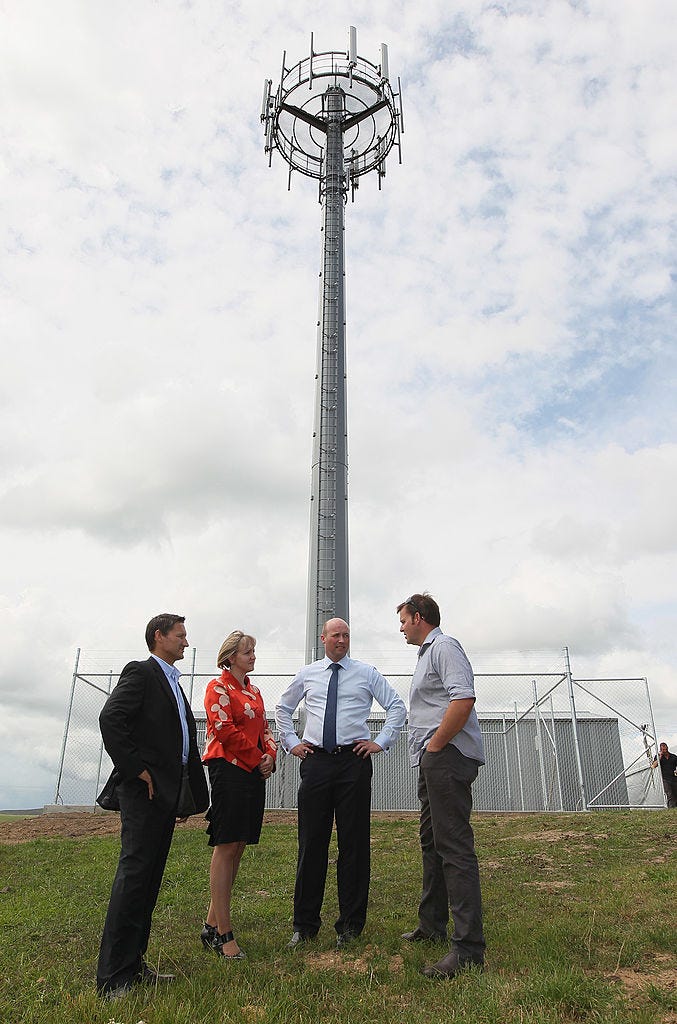 Vodafone CEO Russell Stanners (left) with others in front of an ultra-fast broadband tower in Hamilton, New Zealand, on February 21, 2012.