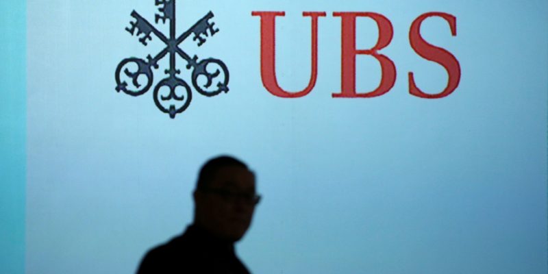 A man walks past a UBS logo projected on a screen in Singapore, January 14, 2019. REUTERS/Feline Lim