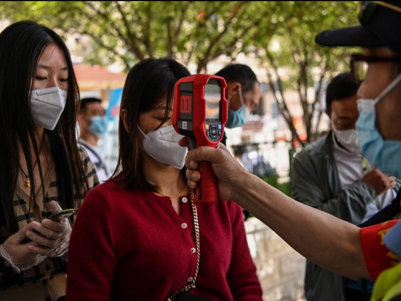Passengers are given temperature checks before boarding a train in Wuhan, China, on May 12, 2020.