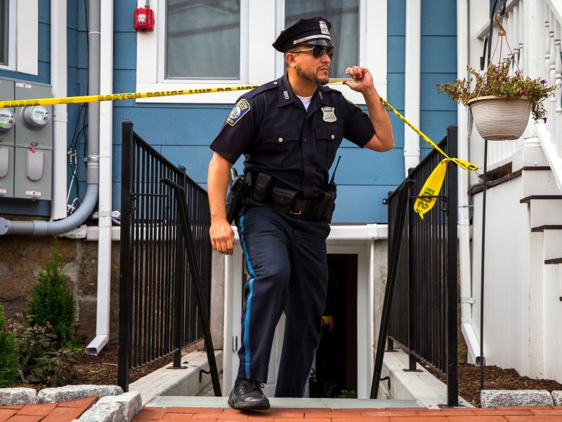 A police officer crosses police tape at the scene of a police killing in Boston, Massachusetts, on September 29, 2019.