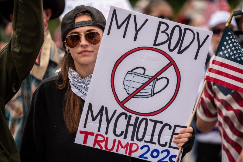A protester holds up a sign protesting wearing a mask at the Texas State Capital building on April 18, 2020 in Austin, Texas.