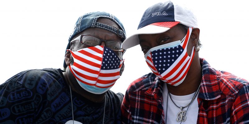 NEW YORK, NEW YORK - MAY 25: A couple wearing American Flag protective masks pose for a photogrpah on Coney Island during the coronavirus pandemic on May 25, 2020 in Brooklyn Borough of New York City. Government guidelines encourage wearing a mask in public with strong social distancing in effect as all 50 states in the USA have begun a gradual process to slowly reopen after weeks of stay-at-home measures to slow the spread of COVID-19. (Photo by John Lamparski/Getty Images)