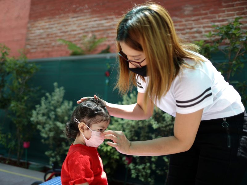 Linda Mejia, 24, puts a mask on her two-year-old daughter Linda at California Hospital Medical Center’s Hope Street Margolis Family Center, amid the outbreak of the coronavirus disease (COVID-19), in Los Angeles