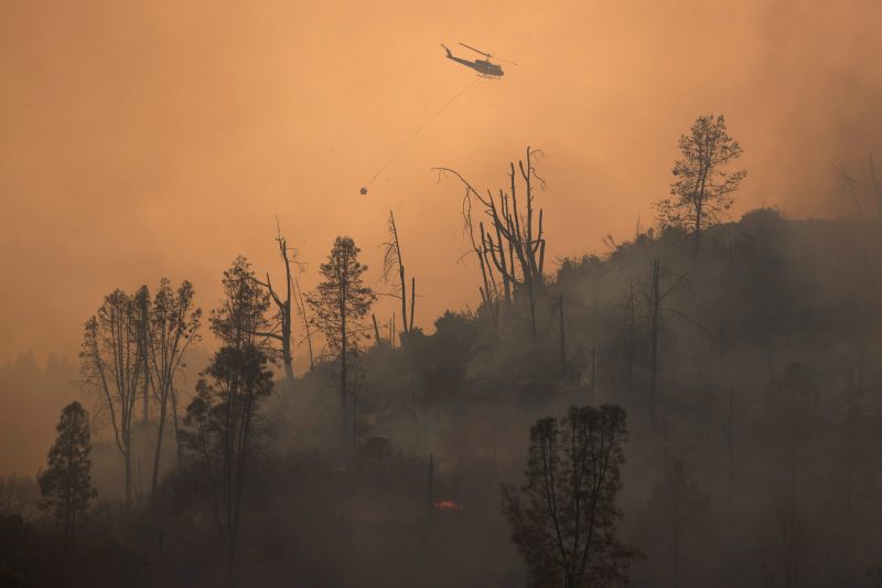 A helicopter and crew releases water to extinguish a section of the LNU Lightning Complex Fire near Middletown, California, U.S. August 24, 2020.