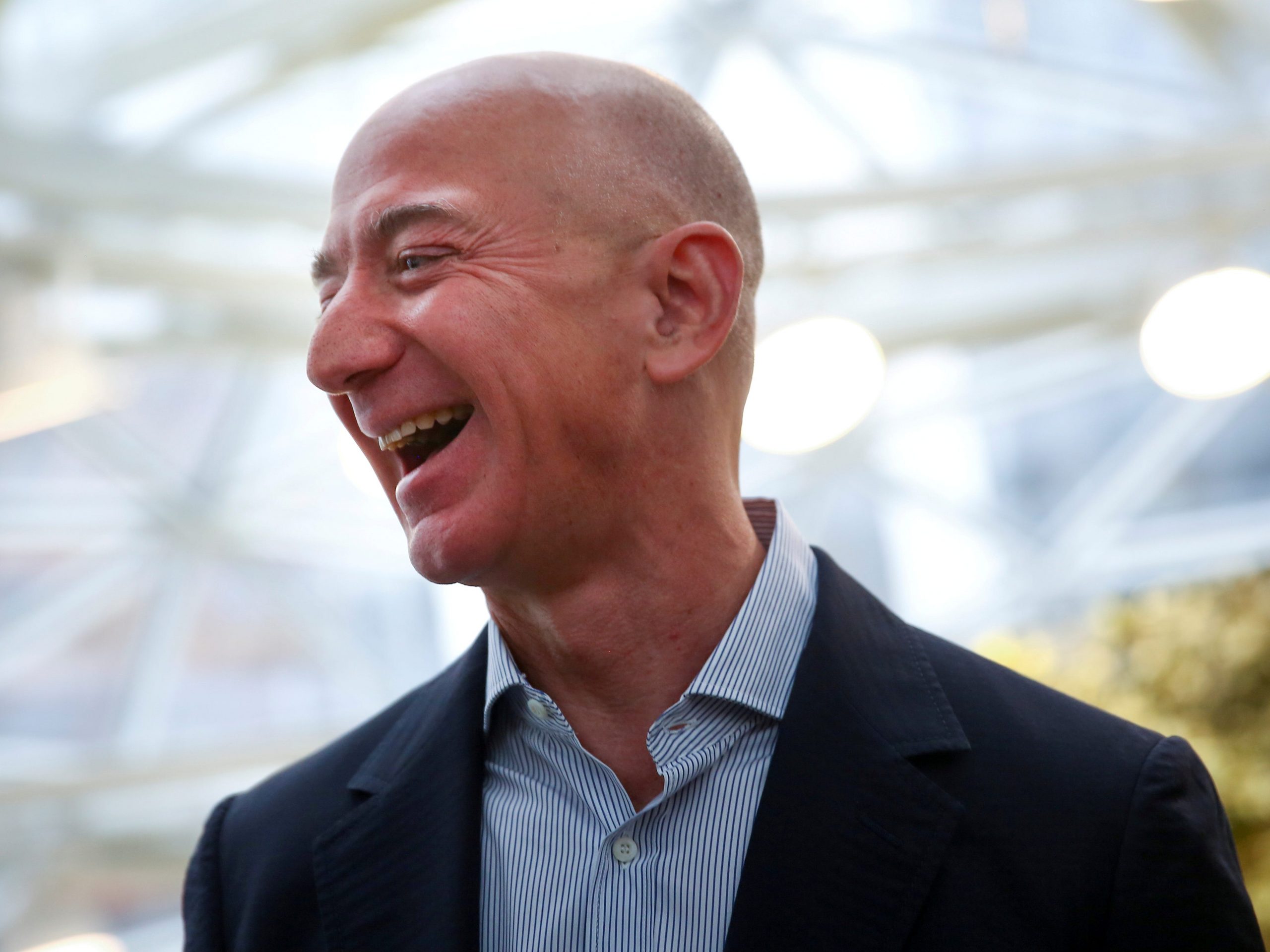 FILE PHOTO: Amazon founder and CEO Jeff Bezos laughs as he talks to the media while touring the new Amazon Spheres during the grand opening at Amazon's Seattle headquarters in Seattle, Washington, U.S., January 29, 2018.   REUTERS/Lindsey Wasson