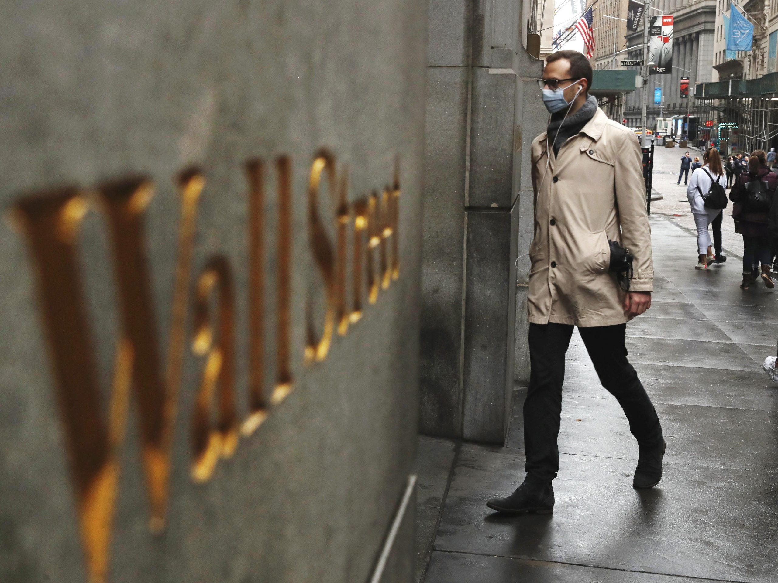 A man wears a protective mask as he walks on Wall Street during the coronavirus outbreak in New York
