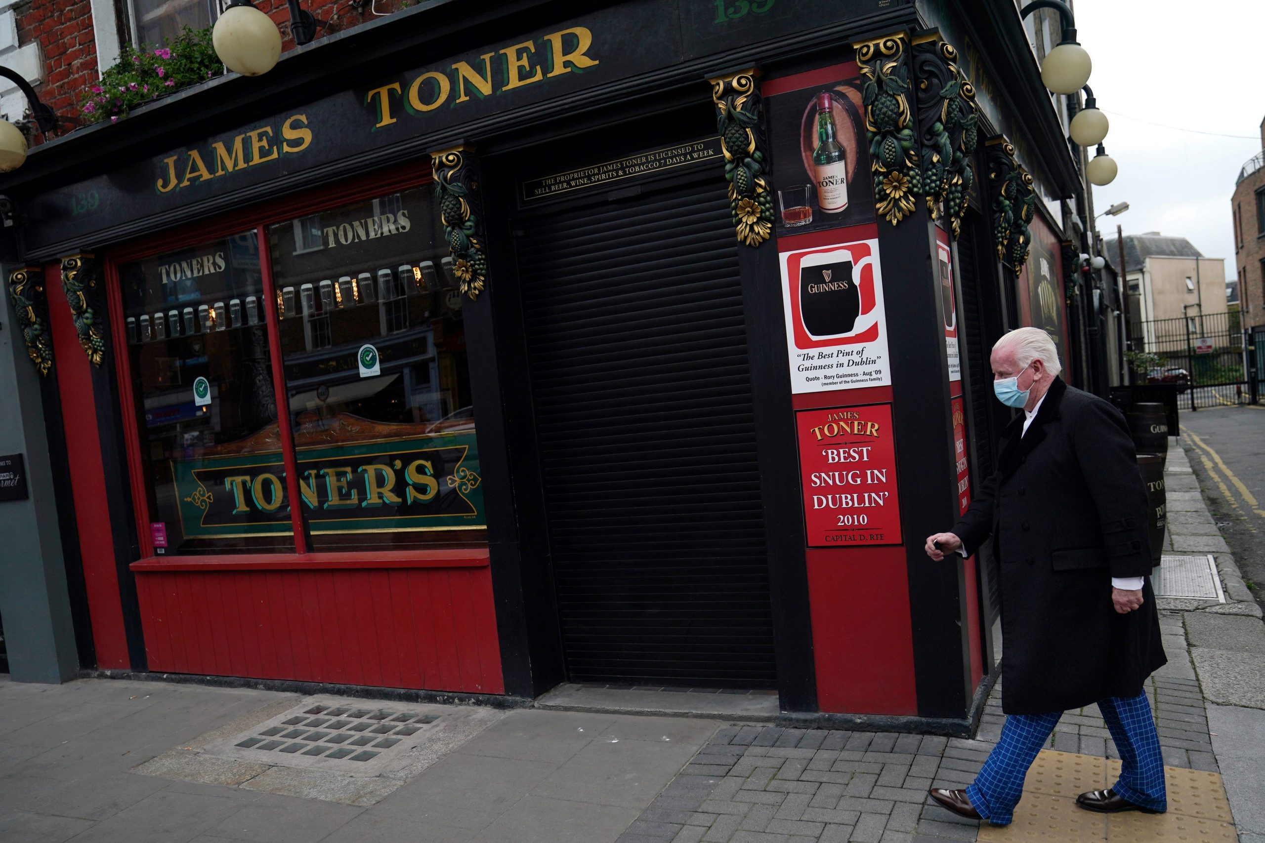 A man wearing a protective face mask walks past a closed pub amid the coronavirus disease (COVID-19) outbreak, in Dublin, Ireland October 1, 2020.
