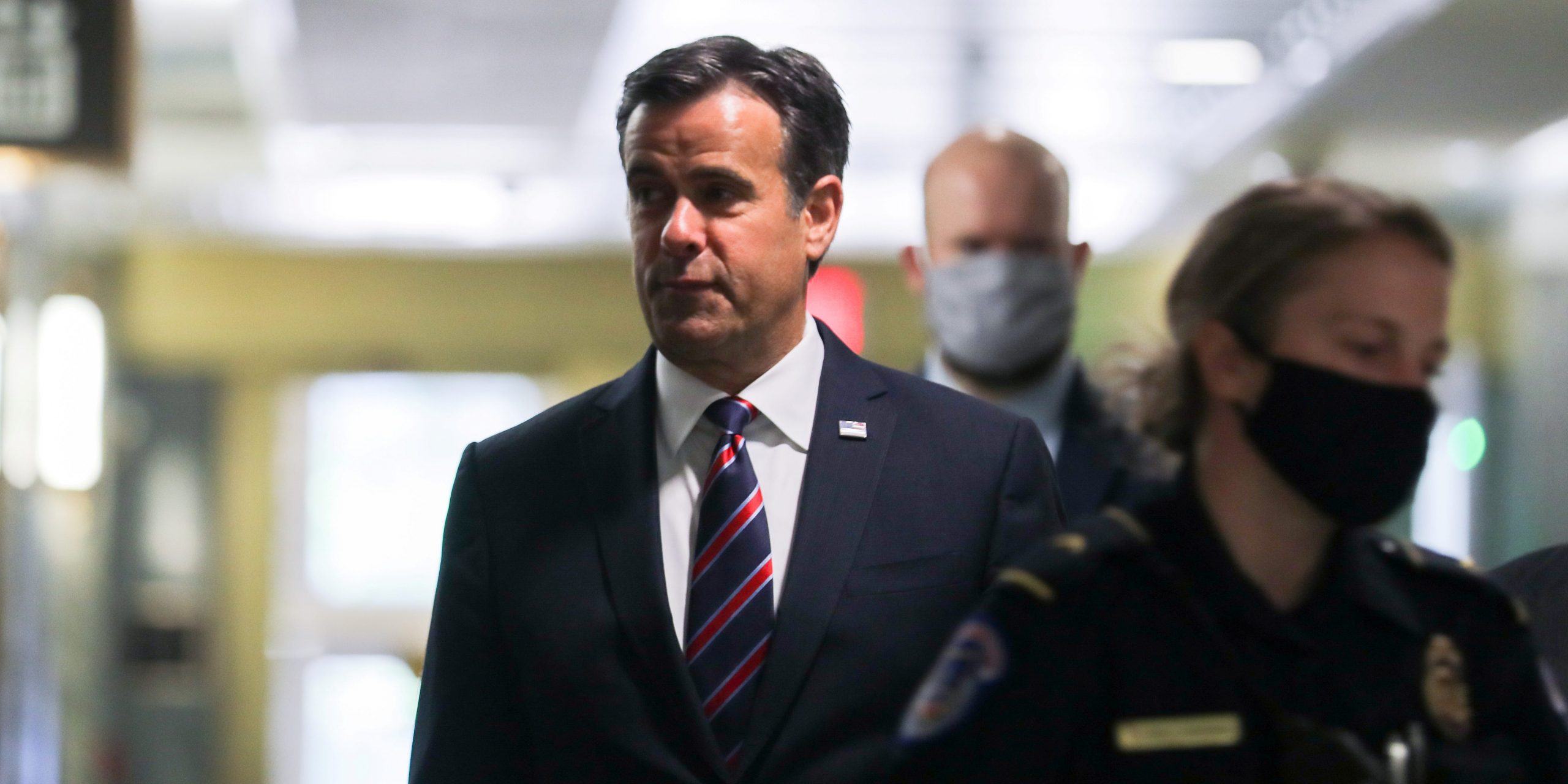 FILE PHOTO: U.S. Rep. John Ratcliffe (R-TX), President Donald Trump's nominee to be Director of National Intelligence, is escorted by U.S. Capitol police officers and other security officials wearing face masks because of the COVID-19 disease outbreak as he arrives to testify at his U.S. Senate confirmation hearing in front of the Senate Intelligence Committee in Washington, U.S. May 5, 2020.  REUTERS/Carlos Barria