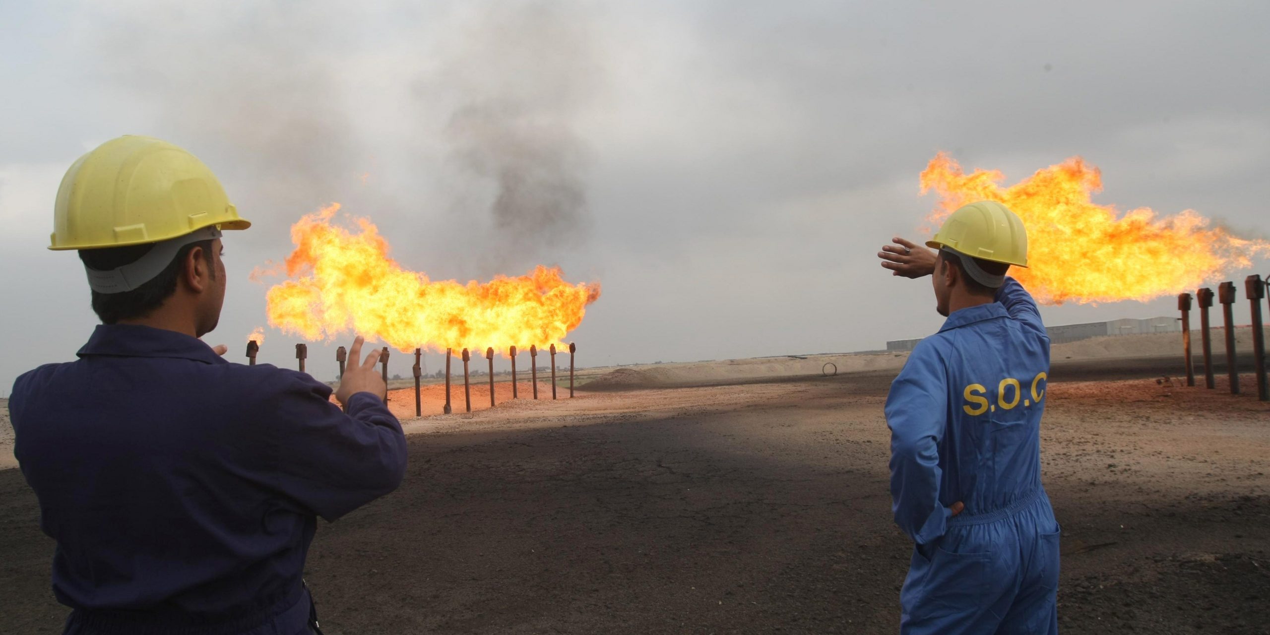 Iraqi Southern Oil Company engineers look towards the flares in the Zubair oil field