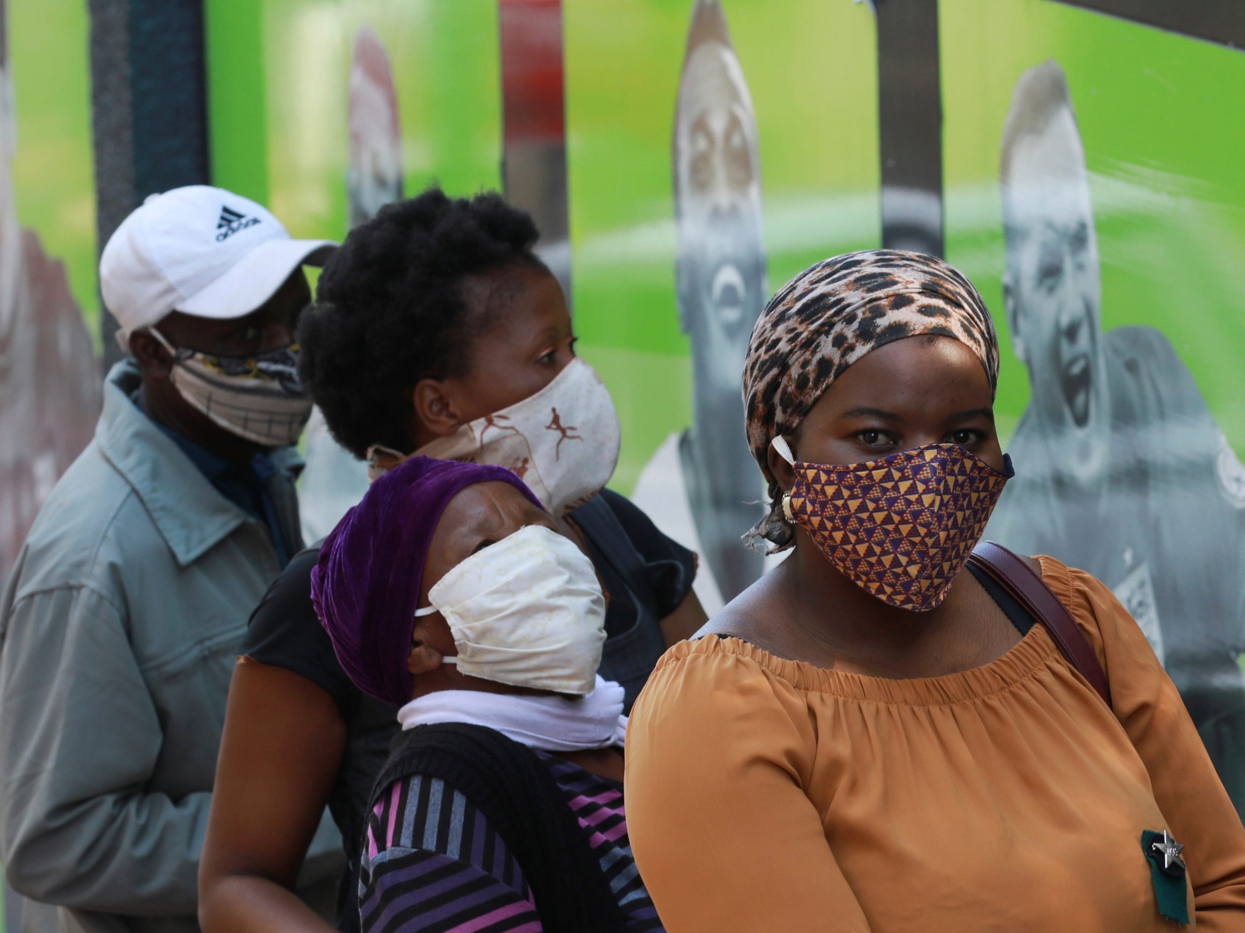 People wearing face masks queue at a South African Social Security Agency (SASSA) to collect their government grant in Cape Town South Africa, Monday, May 11, 2020. South Africa's Western Cape province, which includes the city of Cape Town, has emerged as the country's coronavirus hotspot, accounting for more than half of the nation's confirmed cases, which have gone above 10,000.(AP Photo/Nardus Engelbrecht)